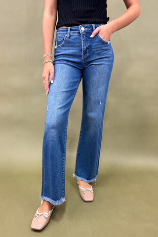 Person wearing blue jeans on a plain background