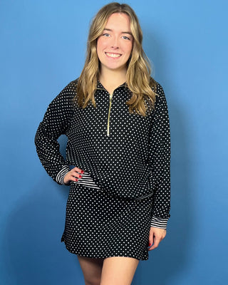 Black and white polka dot quarter zip top with gold zipper, striped trim, long sleeves, and relaxed fit.
