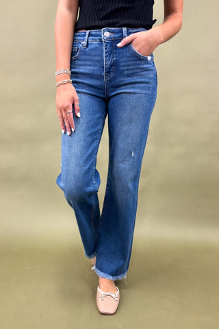 Person wearing blue jeans on a beige background