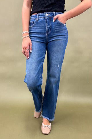 Person wearing blue jeans on a beige background