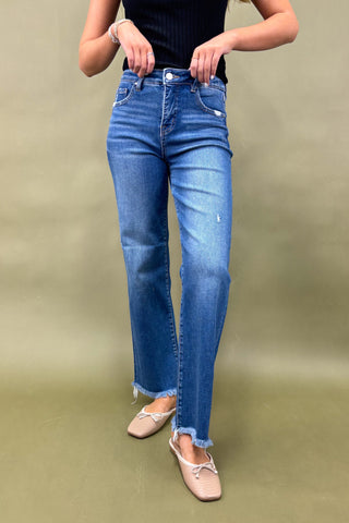 Person wearing blue jeans on a plain background