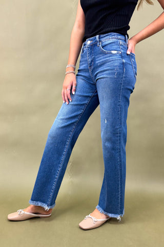 Person wearing blue jeans on a plain background