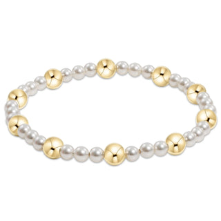 Bracelet with alternating gold and pearl beads on a white background