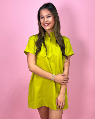 Woman wearing a bright yellow dress against a pink background