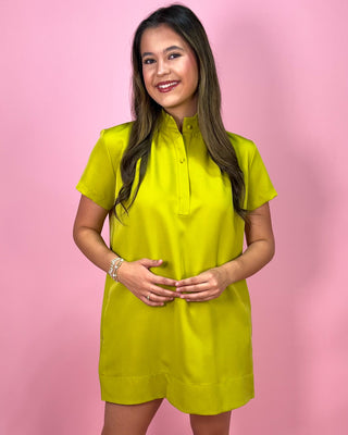 Woman wearing a bright yellow dress against a pink background