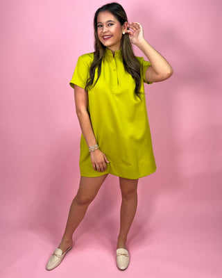 Woman wearing a bright yellow dress against a pink background
