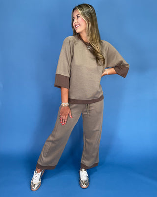 Woman wearing a brown outfit against a blue background