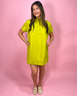 Woman wearing a bright yellow dress against a pink background