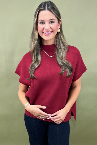Woman wearing a red sweater against a green background