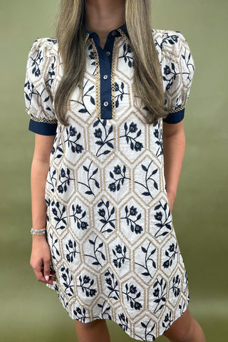 Woman wearing a patterned dress with a geometric design on a green background