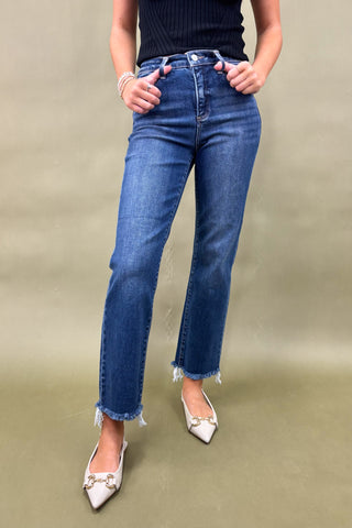 Person wearing blue jeans with a plain background