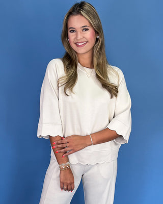 Woman wearing a white outfit against a blue background