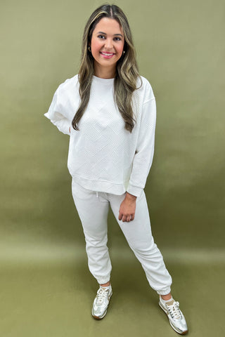 Woman wearing a white outfit against a green background