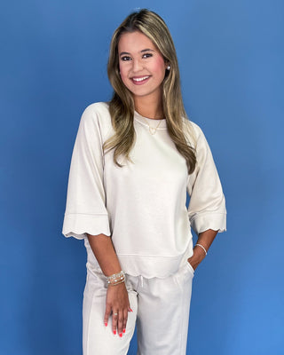 Woman wearing a white outfit against a blue background