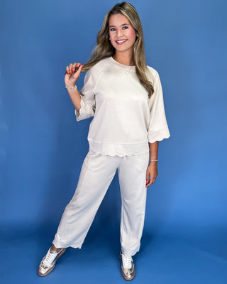 Woman wearing a white outfit against a blue background
