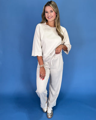 Woman wearing a white outfit against a blue background
