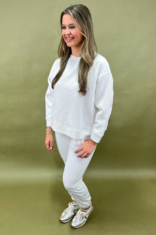 Woman wearing a white outfit against a green background