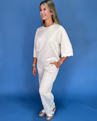Woman wearing a white outfit against a blue background