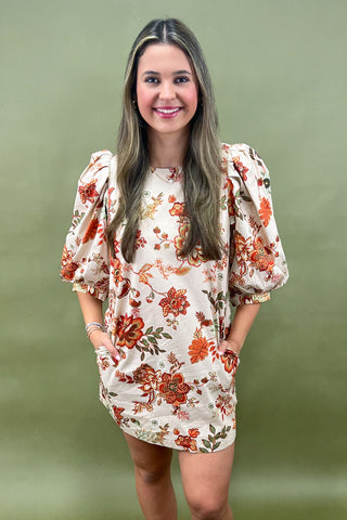 Woman wearing a floral dress against a green background