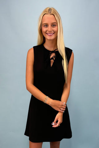 Woman wearing a black dress against a plain background