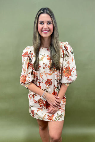 Woman wearing a floral dress against a green background