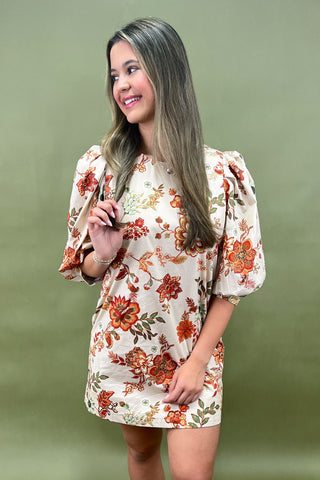 Woman wearing a floral dress against a green background
