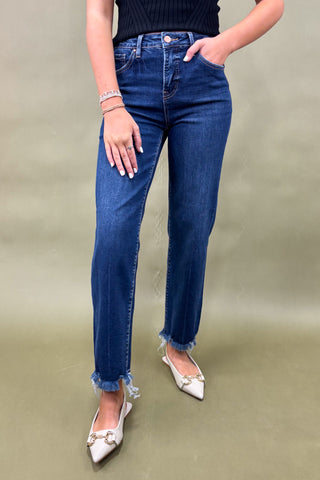 Person wearing blue jeans with a plain background