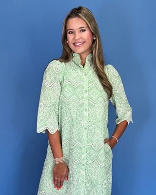 Woman wearing a green patterned dress against a blue background