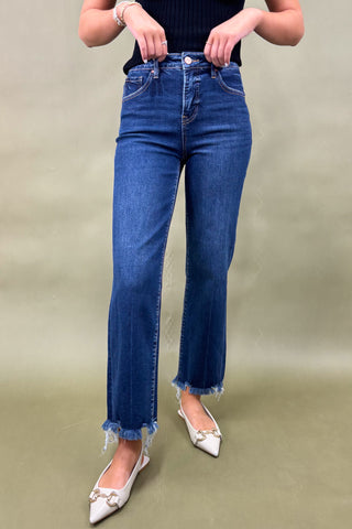 Person wearing blue jeans with a plain background