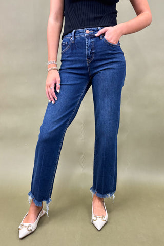 Person wearing blue jeans and white shoes on a plain background