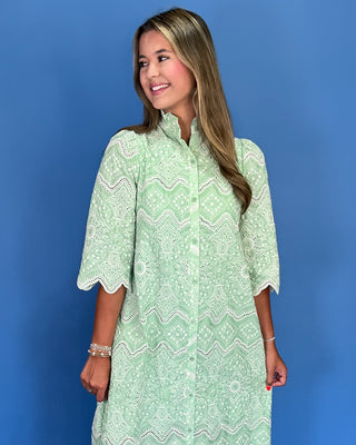 Woman wearing a green lace dress against a blue background
