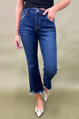 Person wearing blue jeans on a plain background