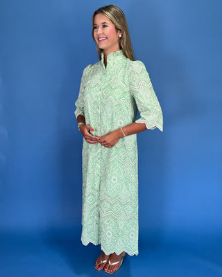 Woman wearing a green patterned dress against a blue background