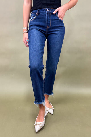 Person wearing blue jeans and white shoes on a plain background