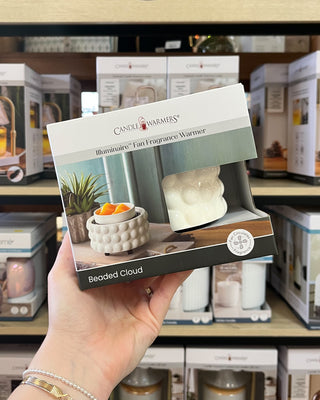 A white ceramic scented wax warmer with a textured bubble pattern and a small bowl of orange wax on top