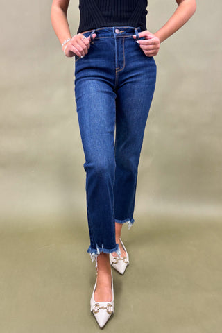 Person wearing blue jeans and white shoes on a plain background