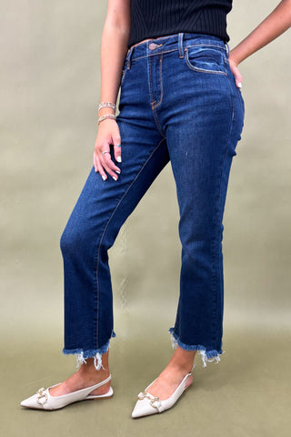 Person wearing blue jeans and white shoes on a plain background