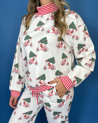 White Christmas pajama set with festive golf cart and Christmas tree print, red striped trim, long sleeves, and jogger pants.