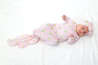 Newborn baby wrapped in a pink swaddle with a white background