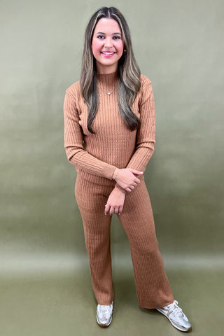 Woman wearing a brown ribbed knit outfit against a green background