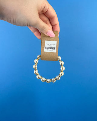 Shop the Pearl Bracelet featuring elegant white faux pearls in polished gold-tone settings with a comfortable stretch fit for timeless style.