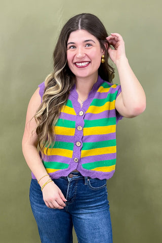 Woman wearing a colorful striped cardigan against a green background