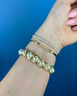 Shop the Pearl Bracelet featuring elegant white faux pearls in polished gold-tone settings with a comfortable stretch fit for timeless style.