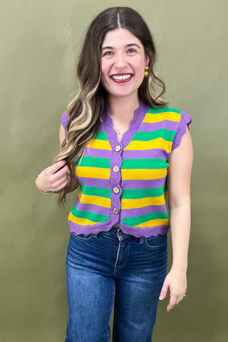 Woman wearing a colorful striped cardigan against a green background