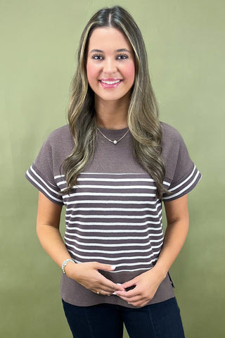 Woman wearing a striped shirt against a green background
