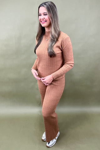 Woman wearing a brown ribbed knit outfit against a plain background