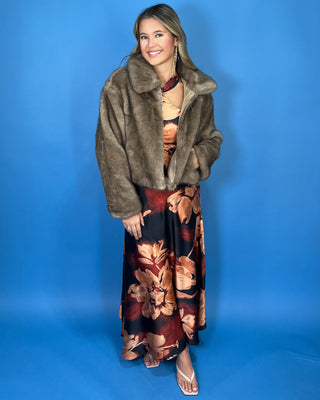 Taupe faux fur cropped jacket with plush texture, oversized collar, long sleeves, and front zipper closure.
