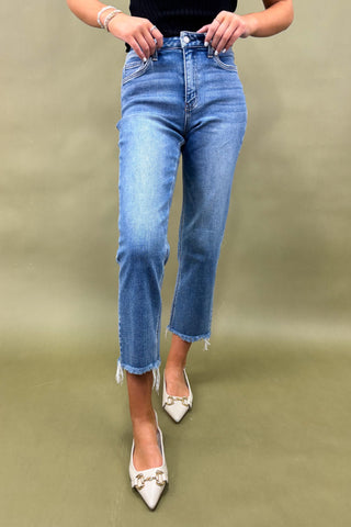 Person wearing blue jeans and white shoes on a green background