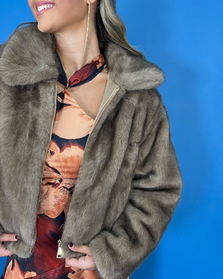 Taupe faux fur cropped jacket with plush texture, oversized collar, long sleeves, and front zipper closure.