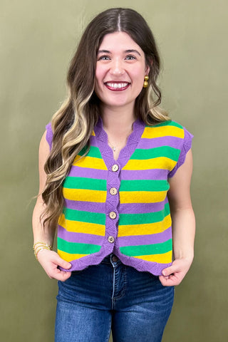 Woman wearing a colorful striped vest against a green background